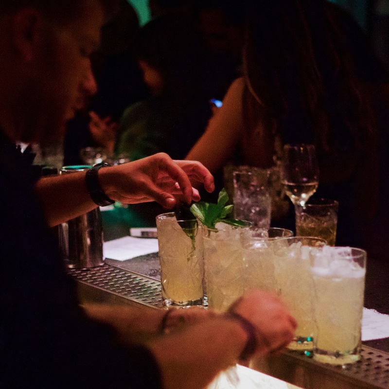 Mixologist preparing cocktails at an event with a mobile cocktail bar