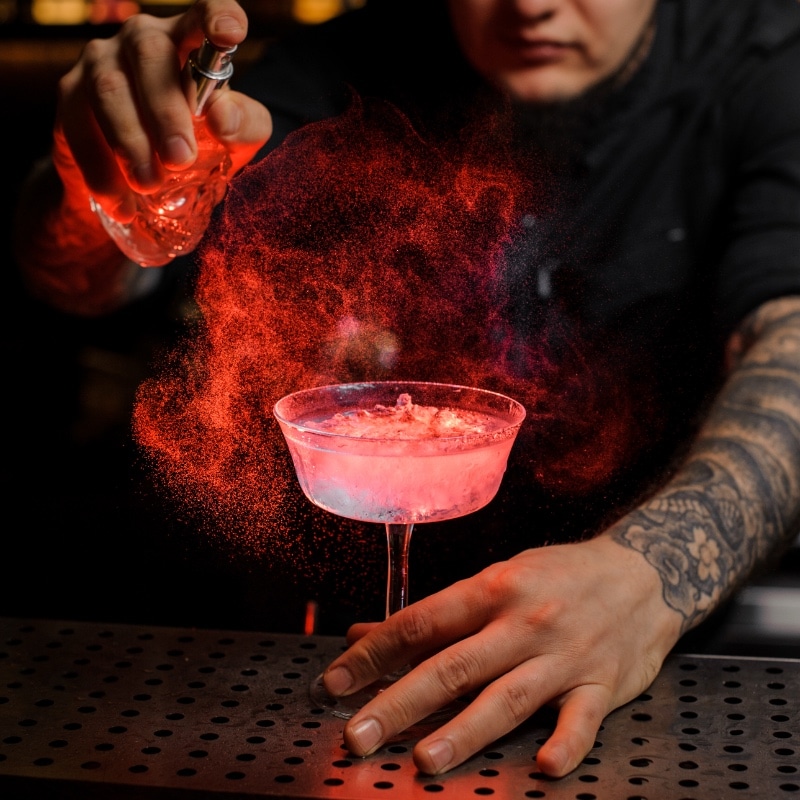 Mixologist preparing pink cocktail on a mobile cocktail bar