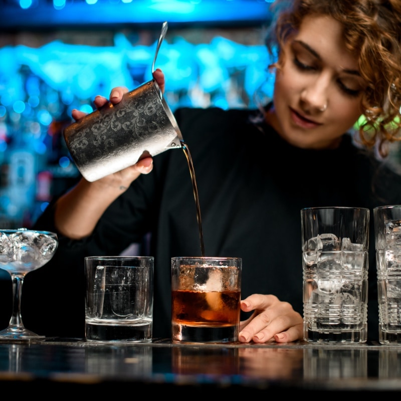 Mixologist preparing cocktails and mocktails at a conference mobile bar