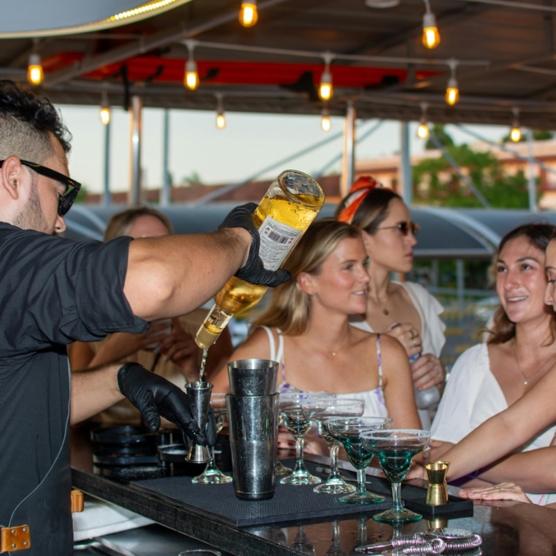 Mixologist preparing cocktails at an event with a mobile cocktail bar